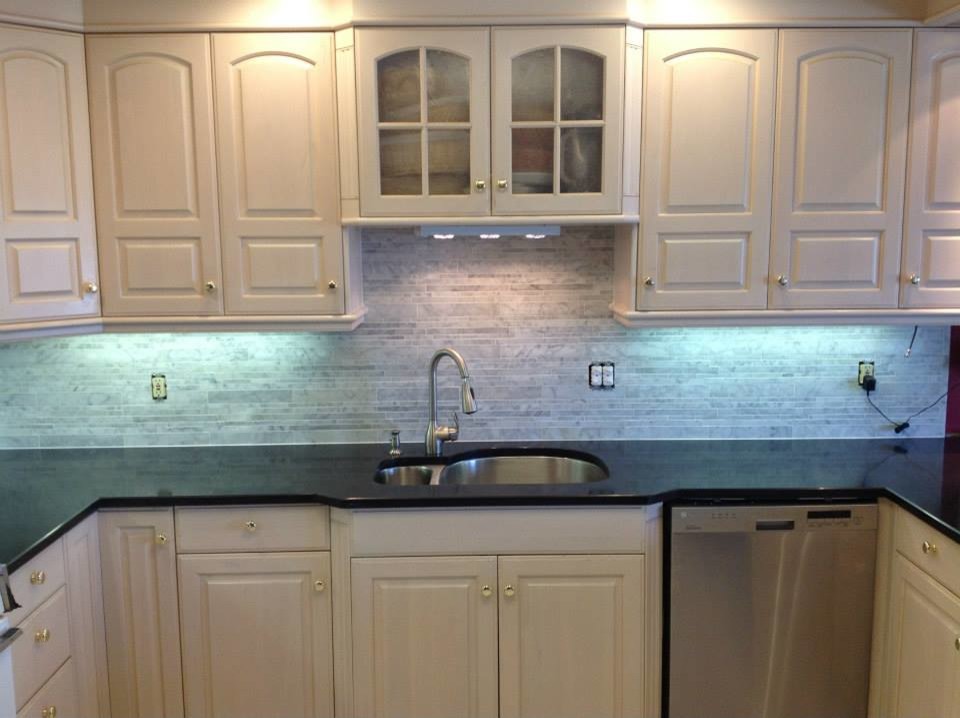 Open concept kitchen - mid-sized u-shaped open concept kitchen idea with a double-bowl sink, raised-panel cabinets, white cabinets, onyx countertops, gray backsplash, ceramic backsplash and stainless steel appliances