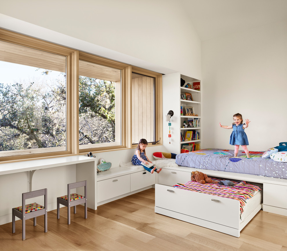 Idee per una cameretta per bambini moderna con pareti bianche, parquet chiaro e soffitto a volta