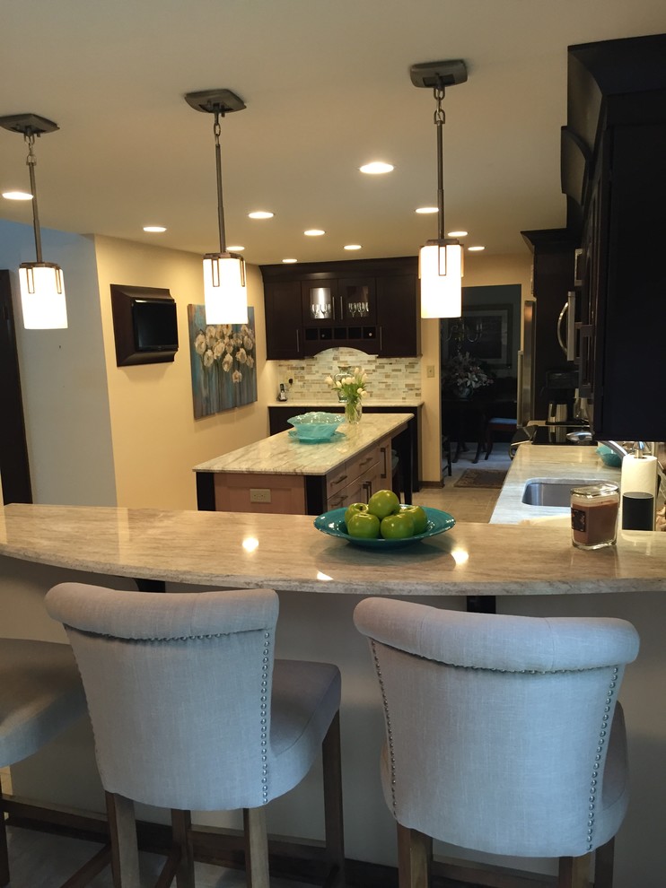 Example of a transitional ceramic tile kitchen design with a single-bowl sink, dark wood cabinets, multicolored backsplash, mosaic tile backsplash, stainless steel appliances and an island