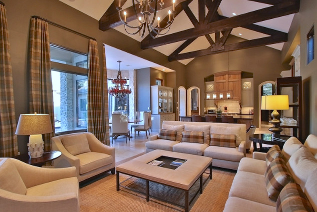 This is an example of a large transitional open concept family room in Houston with brown walls, travertine floors, a standard fireplace, a stone fireplace surround and a concealed tv.
