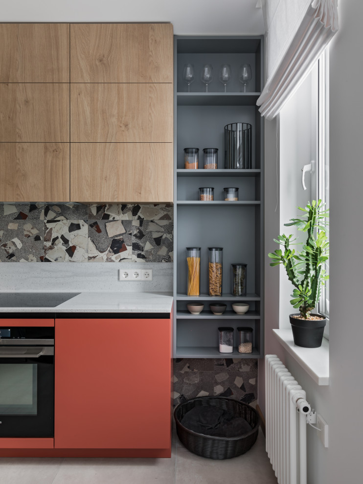Eat-in kitchen - mid-sized industrial porcelain tile and gray floor eat-in kitchen idea in Other with an integrated sink, flat-panel cabinets, green cabinets, solid surface countertops, multicolored backsplash, porcelain backsplash, black appliances, no island and white countertops