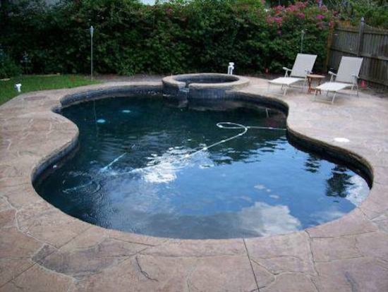 Example of a small transitional backyard concrete paver and custom-shaped hot tub design in Tampa