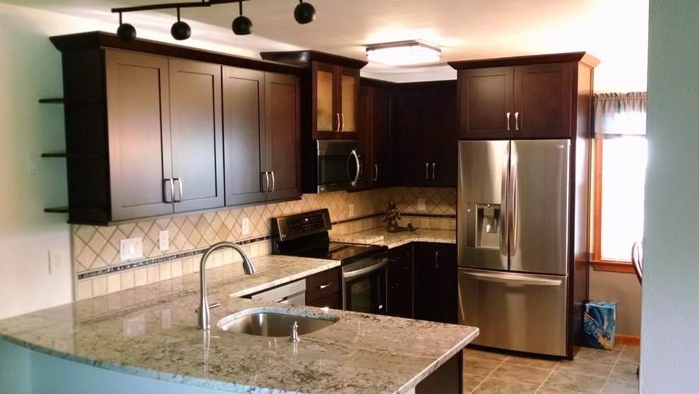 Example of a mid-sized transitional u-shaped porcelain tile eat-in kitchen design with an undermount sink, shaker cabinets, dark wood cabinets, granite countertops, beige backsplash, stone tile backsplash, stainless steel appliances and a peninsula
