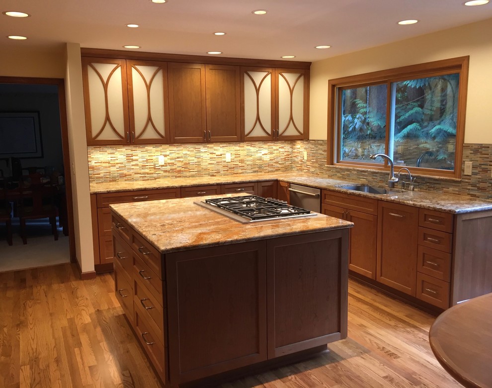 Mid-sized eclectic u-shaped medium tone wood floor and brown floor eat-in kitchen photo in Seattle with an undermount sink, shaker cabinets, medium tone wood cabinets, granite countertops, multicolored backsplash, stainless steel appliances, an island and mosaic tile backsplash