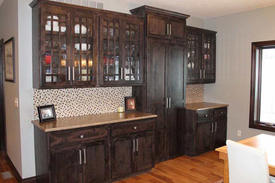 Expansive modern single-wall kitchen pantry in Kansas City with glass-front cabinets, dark wood cabinets, laminate benchtops, brown splashback, mosaic tile splashback and medium hardwood floors.