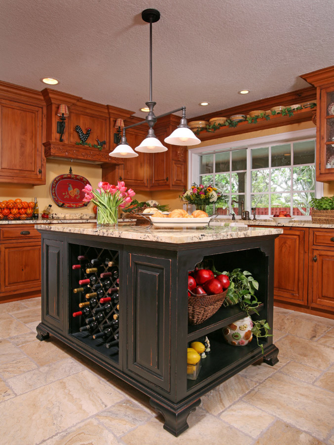 Inspiration for a mid-sized rustic u-shaped travertine floor enclosed kitchen remodel in Miami with a farmhouse sink, raised-panel cabinets, medium tone wood cabinets, granite countertops, yellow backsplash and an island