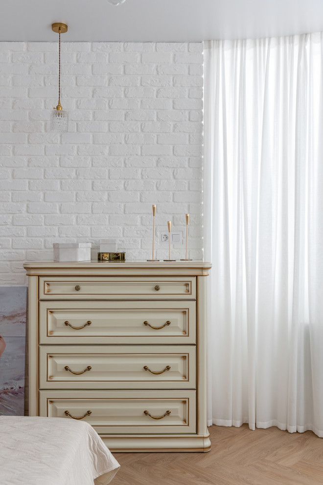 Aménagement d'une chambre parentale blanche et bois classique de taille moyenne avec un mur blanc, un sol en bois brun, un sol beige, poutres apparentes et un mur en parement de brique.