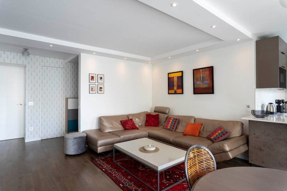 Photo of a medium sized contemporary open plan games room in Paris with white walls, medium hardwood flooring, a freestanding tv and brown floors.