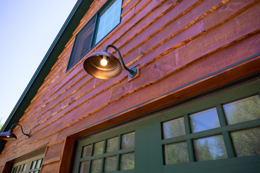 Ejemplo de fachada de casa marrón rural de dos plantas con revestimiento de madera, tejado de metal, tablilla y tejado a dos aguas