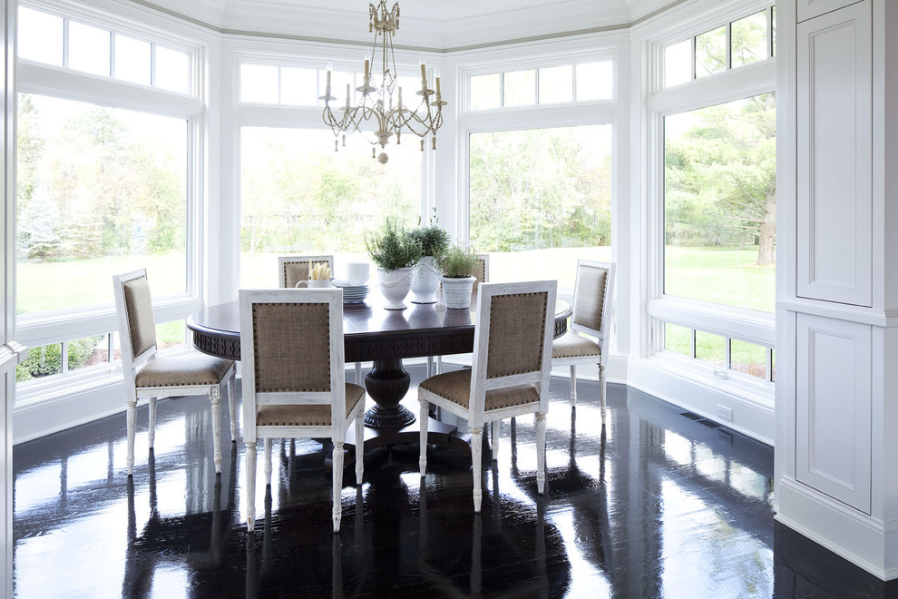 This is an example of a mid-sized transitional dining room in Minneapolis with painted wood floors, white walls, no fireplace and black floor.