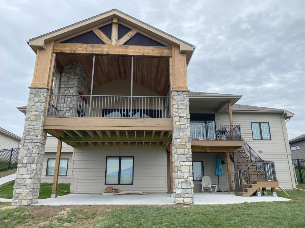 Foto de terraza de estilo americano grande en patio trasero y anexo de casas con chimenea y barandilla de metal