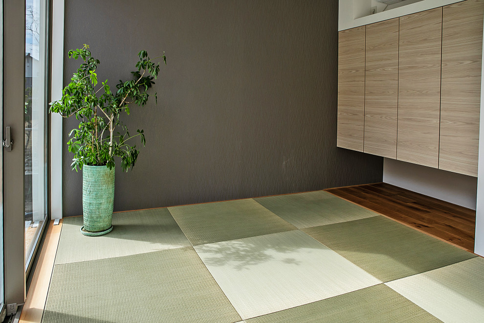 Modelo de habitación de invitados actual sin chimenea con tatami, suelo verde y papel pintado