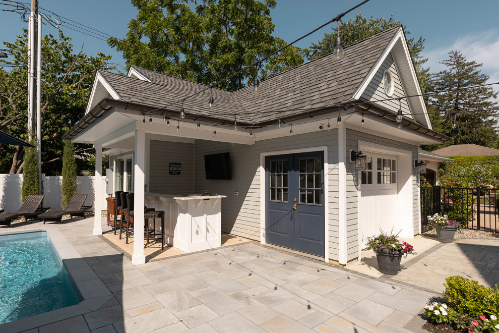 Photo of a medium sized traditional back rectangular swimming pool in New York with a pool house and concrete paving.
