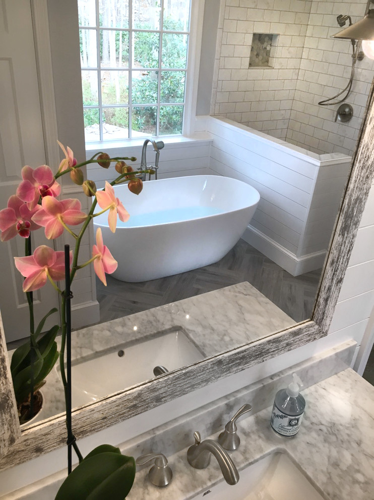 Mid-sized country master bathroom in Atlanta with shaker cabinets, grey cabinets, a freestanding tub, a corner shower, a two-piece toilet, white tile, ceramic tile, grey walls, ceramic floors, an undermount sink, marble benchtops, grey floor and a hinged shower door.