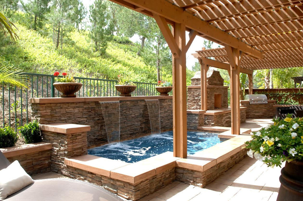 Inspiration for a mid-sized transitional backyard concrete paver and custom-shaped hot tub remodel in Orange County
