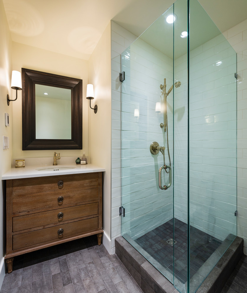 Example of a small mountain style 3/4 white tile and ceramic tile porcelain tile and gray floor corner shower design in Vancouver with flat-panel cabinets, medium tone wood cabinets, beige walls, an undermount sink, quartz countertops, a hinged shower door and white countertops