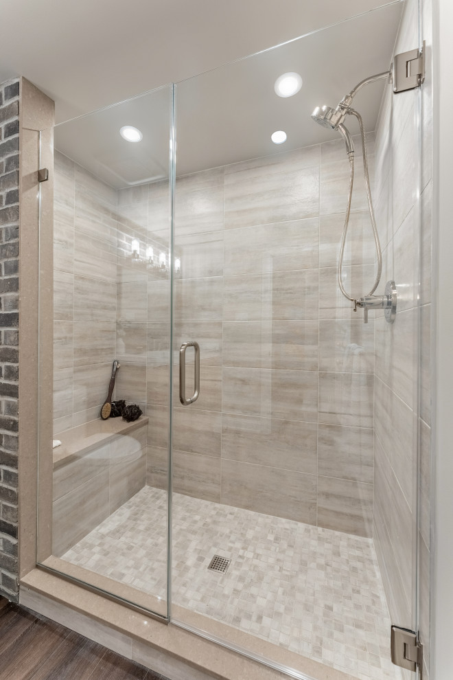 Photo of a large traditional shower room bathroom in Philadelphia with flat-panel cabinets, brown cabinets, an alcove shower, a one-piece toilet, grey tiles, porcelain tiles, grey walls, vinyl flooring, an integrated sink, solid surface worktops, grey floors, a hinged door, white worktops, a shower bench, a single sink, a built in vanity unit and brick walls.