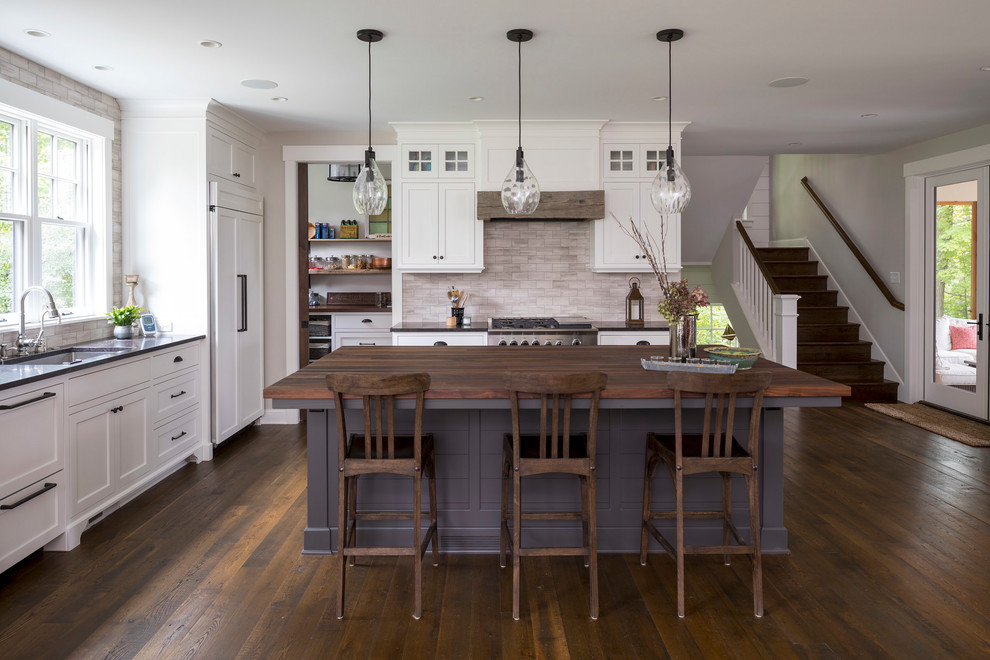 Inspiration for a beach style kitchen in Minneapolis with an undermount sink, shaker cabinets, white cabinets, wood benchtops, grey splashback, dark hardwood floors, with island, brown floor and panelled appliances.