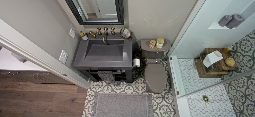 Photo of a small eclectic 3/4 bathroom in San Francisco with gray tile, grey walls, concrete floors, open cabinets, an alcove shower, a two-piece toilet, a console sink and concrete benchtops.