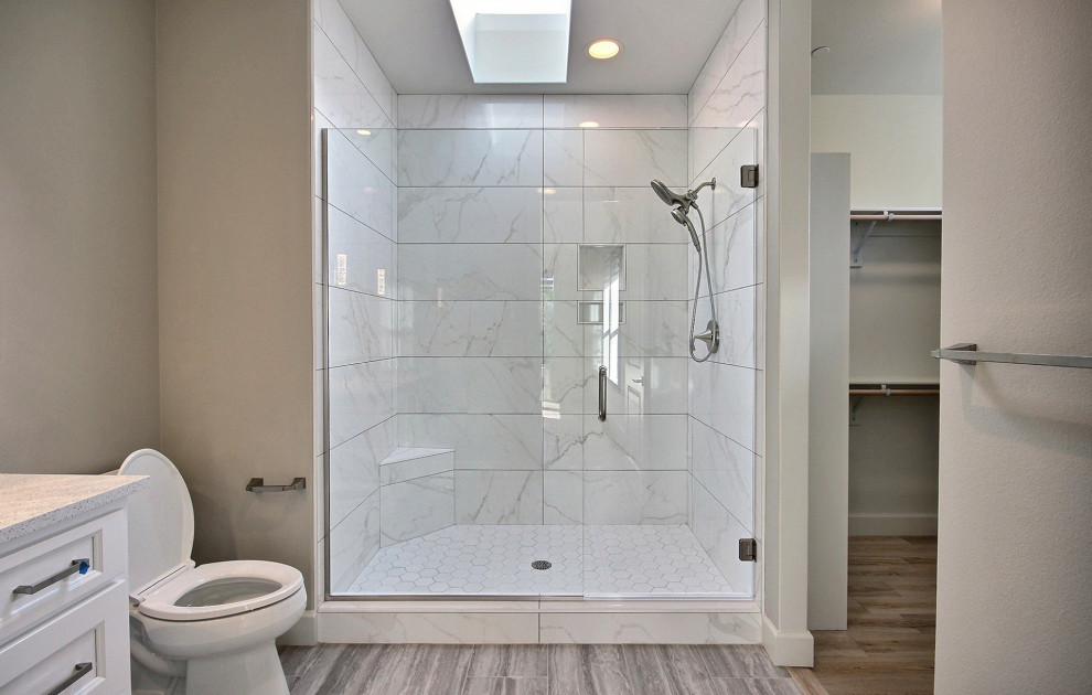 Design ideas for an expansive modern shower room bathroom in Portland with recessed-panel cabinets, white cabinets, an alcove shower, a two-piece toilet, white tiles, ceramic tiles, beige walls, ceramic flooring, a submerged sink, granite worktops, grey floors, a hinged door, white worktops, a shower bench, a single sink and a built in vanity unit.