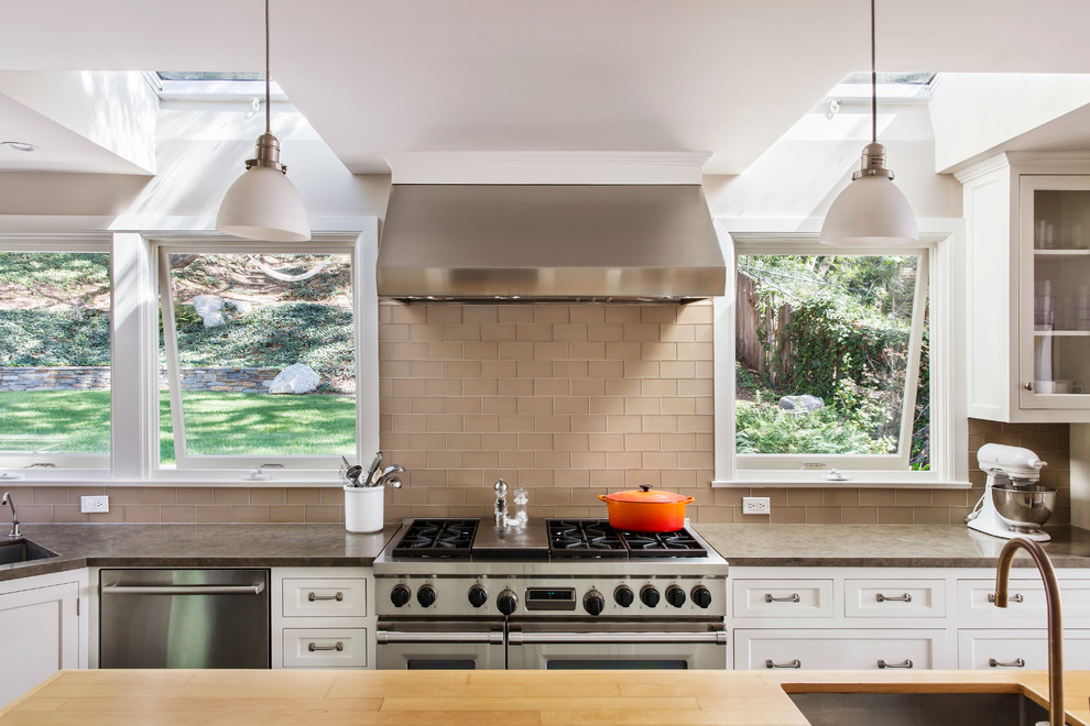Inspiration for a transitional kitchen in Los Angeles with an undermount sink, recessed-panel cabinets, white cabinets, beige splashback, glass tile splashback, stainless steel appliances and with island.