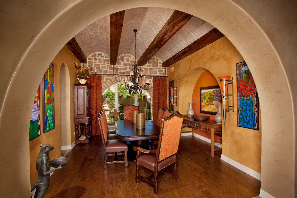 Design ideas for a mediterranean separate dining room in Austin with dark hardwood floors and yellow walls.