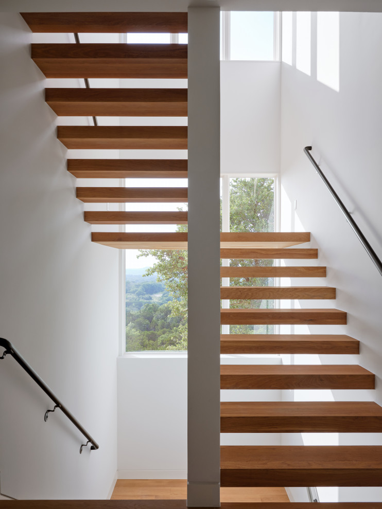 Diseño de escalera en U actual de tamaño medio sin contrahuella con escalones de madera y barandilla de metal