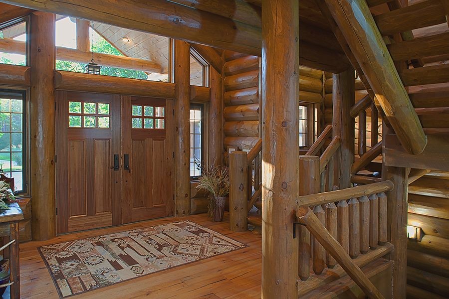 This is an example of a mid-sized foyer in Other with brown walls, light hardwood floors, a double front door and a medium wood front door.