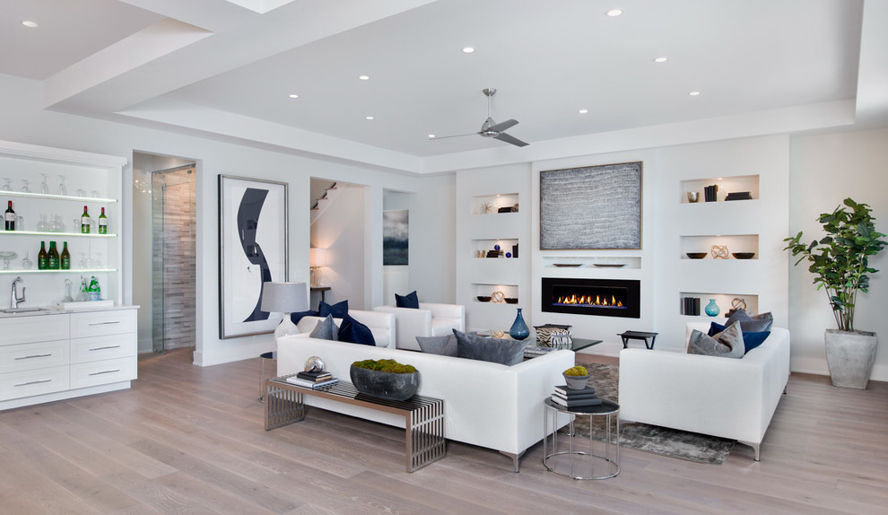 Inspiration for a contemporary open concept living room in Los Angeles with white walls, medium hardwood floors and a standard fireplace.