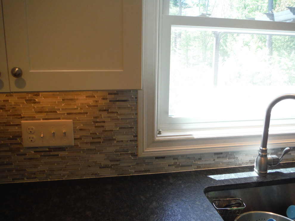 Eat-in kitchen - transitional l-shaped eat-in kitchen idea in Boston with a drop-in sink, shaker cabinets, white cabinets, granite countertops, beige backsplash, mosaic tile backsplash and no island