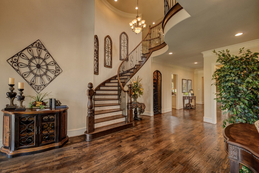 Expansive mediterranean wood curved staircase in Dallas with tile risers.