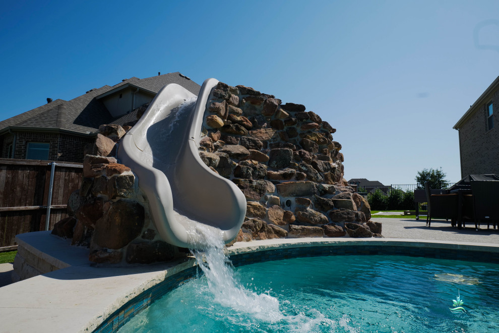 Стильный дизайн: огромный естественный бассейн произвольной формы на боковом дворе в стиле фьюжн с водной горкой и настилом - последний тренд