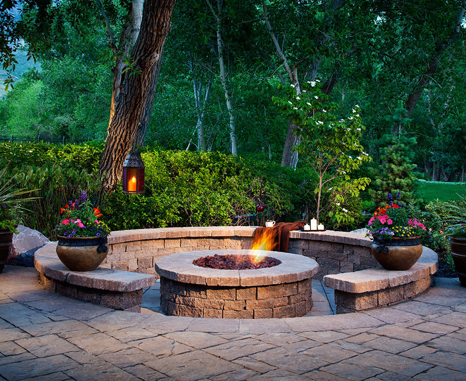 Mid-sized country backyard patio in Denver with a fire feature, natural stone pavers and no cover.