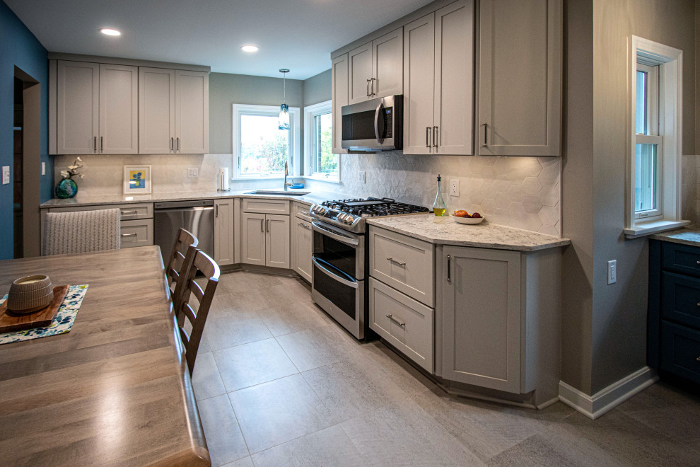 This is an example of a medium sized classic l-shaped kitchen/diner in Cleveland with a submerged sink, flat-panel cabinets, white cabinets, engineered stone countertops, white splashback, stainless steel appliances, cement flooring, no island, beige floors and beige worktops.