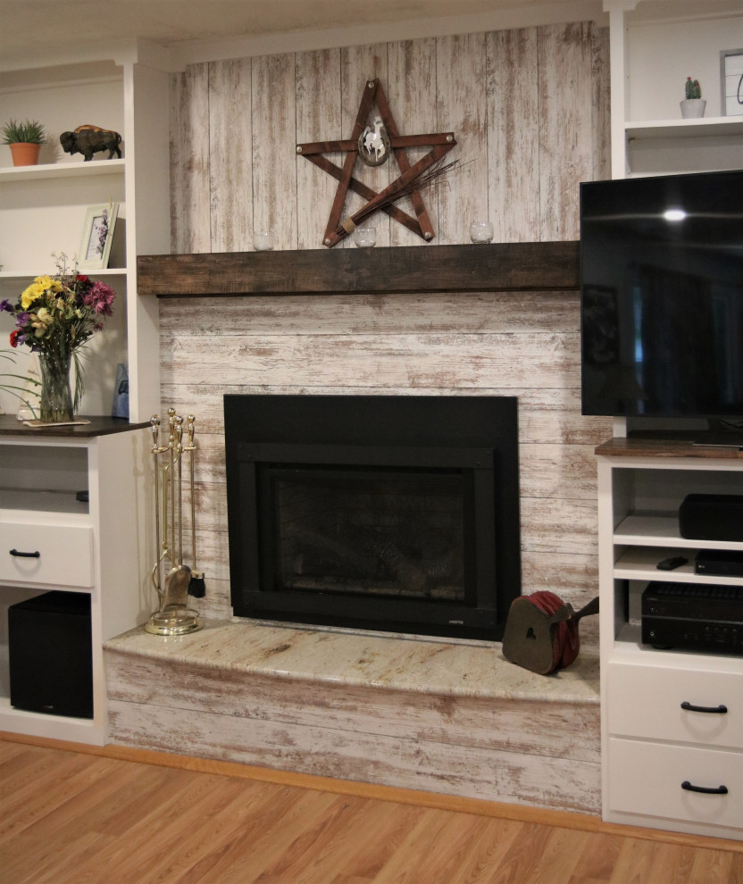 Bild på ett mellanstort rustikt allrum med öppen planlösning, med vita väggar, ljust trägolv, en standard öppen spis, en fristående TV och flerfärgat golv