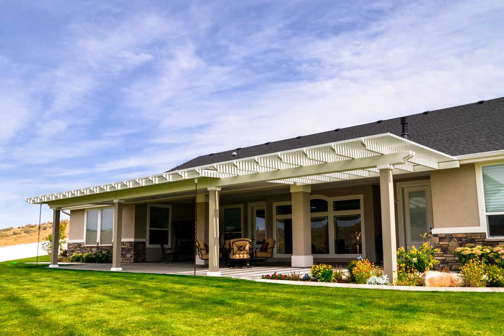 Inspiration for a large transitional backyard patio remodel in Boise with a roof extension