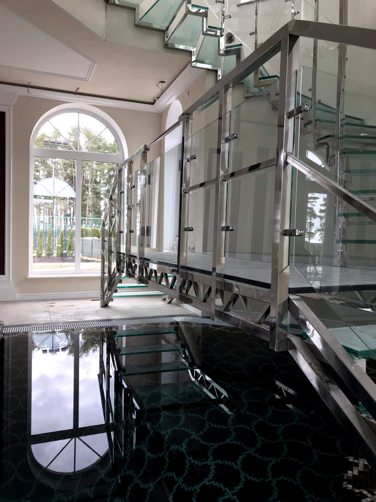 Винтовая стеклянная лестница над бассейном