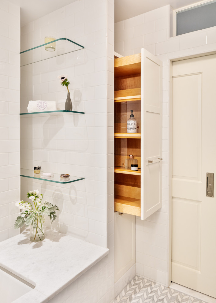 This is an example of a small contemporary ensuite bathroom in New York with white cabinets, a submerged bath, a two-piece toilet, white tiles, porcelain tiles, white walls, mosaic tile flooring, white floors, a wall niche, a single sink and a freestanding vanity unit.