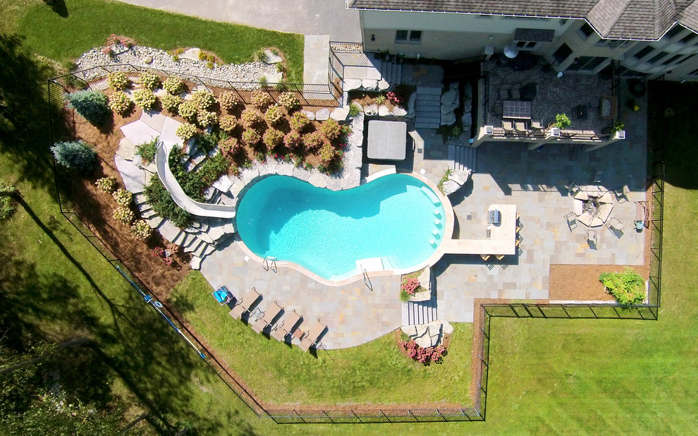 Inspiration for a large transitional backyard stone and custom-shaped water slide remodel in Detroit