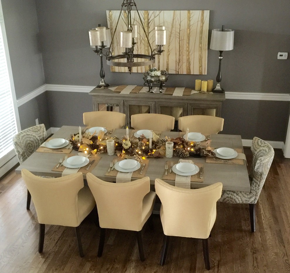 Example of a mid-sized transitional medium tone wood floor and brown floor enclosed dining room design in Cincinnati with gray walls and no fireplace