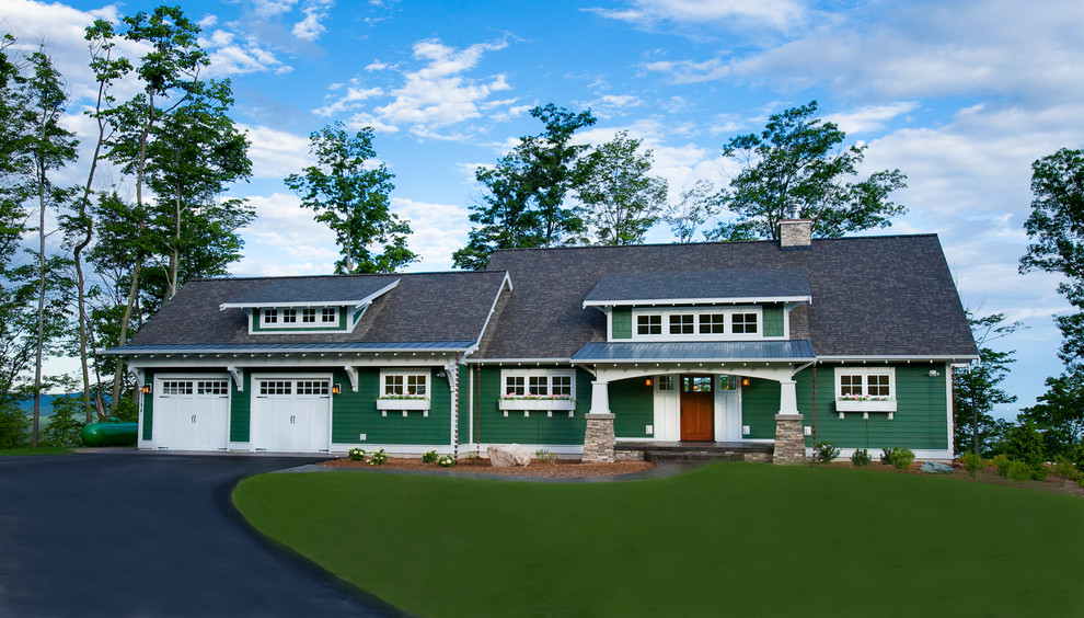 Photo of a large arts and crafts two-storey green exterior in Other with wood siding.