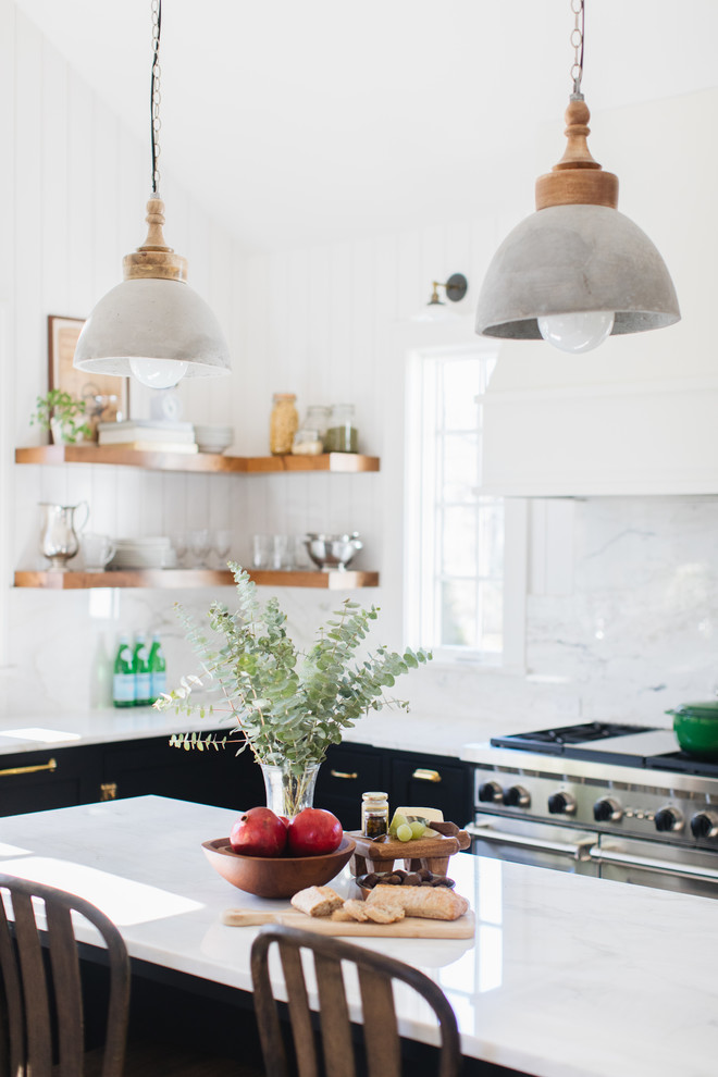 Mid-sized transitional l-shaped medium tone wood floor and brown floor kitchen photo in Chicago with a farmhouse sink, shaker cabinets, black cabinets, marble countertops, white backsplash, marble backsplash, paneled appliances and an island