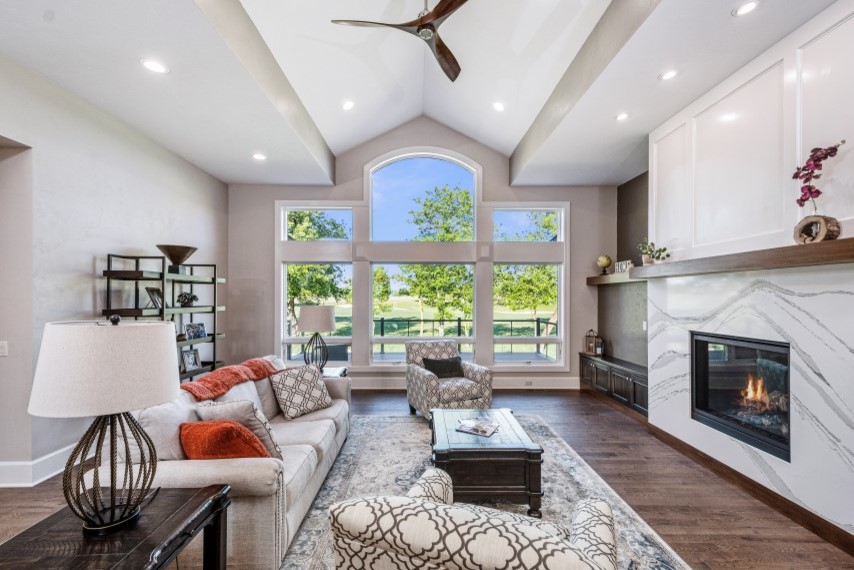 Inspiration for a mid-sized transitional open concept family room in Other with beige walls, dark hardwood floors, a standard fireplace and a corner tv.