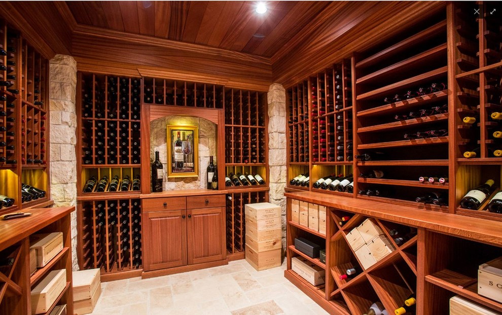 Expansive arts and crafts wine cellar in Orlando with storage racks and travertine floors.