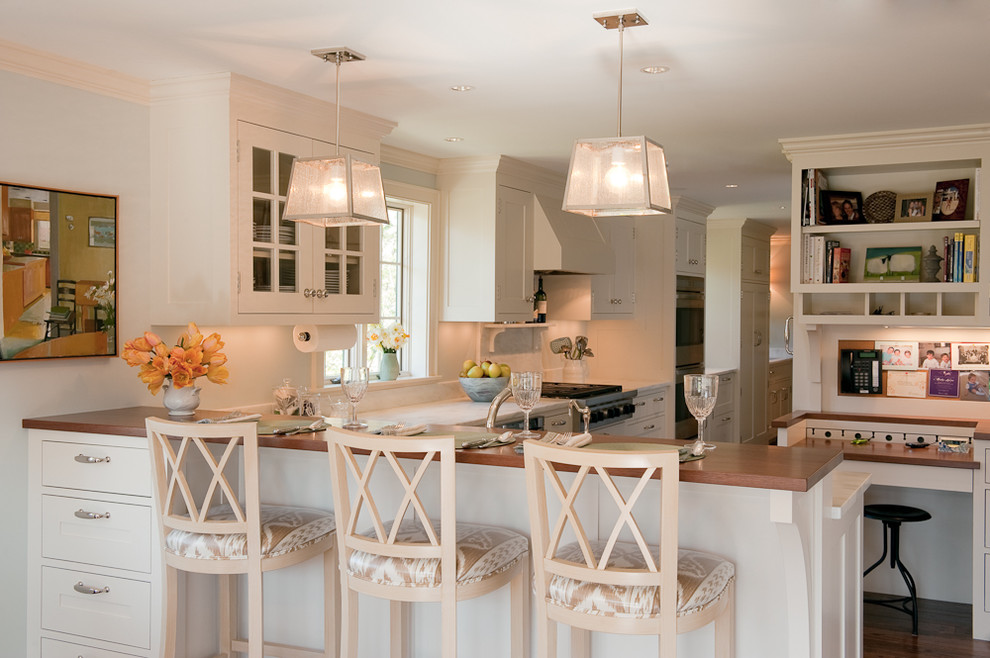 Design ideas for a transitional kitchen in Boston with white cabinets and wood benchtops.
