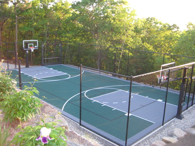 Photo of a mid-sized traditional backyard partial sun outdoor sport court in Boston with natural stone pavers.