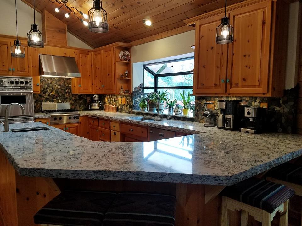 Large mountain style u-shaped eat-in kitchen photo in Sacramento with an undermount sink, raised-panel cabinets, medium tone wood cabinets, quartz countertops, multicolored backsplash, stainless steel appliances and a peninsula