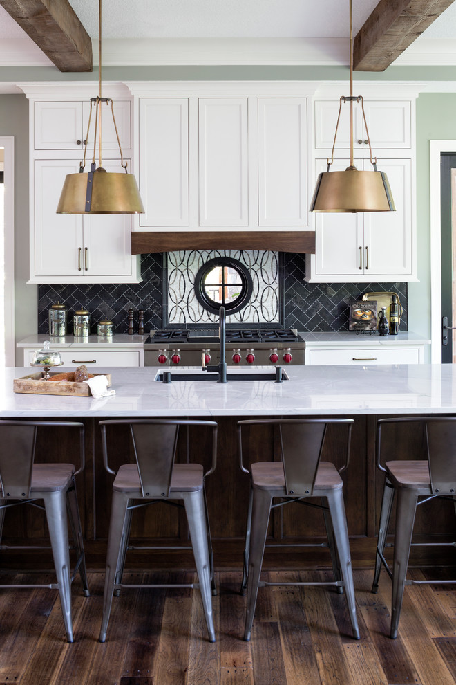 Inspiration for a transitional kitchen in Minneapolis with an undermount sink, shaker cabinets, white cabinets, multi-coloured splashback, stainless steel appliances, dark hardwood floors, with island, brown floor and white benchtop.