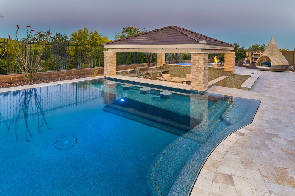 Hot tub - large backyard stone and custom-shaped hot tub idea in Phoenix