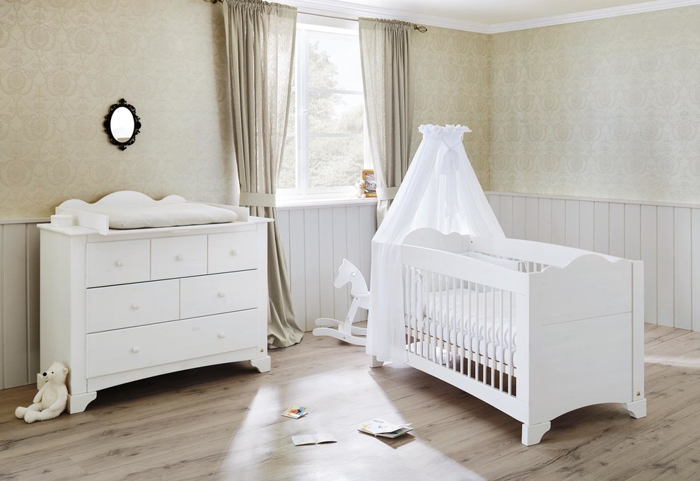This is an example of a country gender-neutral nursery in Hamburg with painted wood floors and multi-coloured walls.